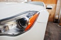 Headlight of white new luxury sport car in detailing garage Royalty Free Stock Photo