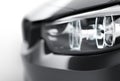 Headlights of black sports car on white