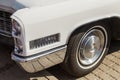 Headlights and chrome-plated bumper of a vintage white Cadillac Coupe de Ville at retro car show Royalty Free Stock Photo