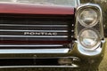 Headlights of a classic red convertible car in a grassy field Royalty Free Stock Photo