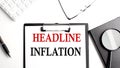 HEADLINE INFLATION text written on paper clipboard with office tools