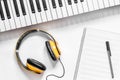 Headphone, notebook and synthesizer in music studio for dj or musician work white desk background top view mock-up Royalty Free Stock Photo