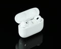 Headphones Apple Air Pods Pro 2 with Wireless Charging Case on black background. AirPods are wireless Bluetooth earbuds designed Royalty Free Stock Photo