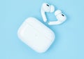 Headphones Apple Air Pods Pro 2 with Wireless Charging Case on blue background, top view. AirPods are wireless Bluetooth earbuds