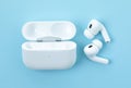 Headphones Apple Air Pods Pro 2 with Wireless Charging Case on blue background, top view. AirPods are wireless Bluetooth earbuds