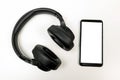 Headphones with Bluetooth technology on white background, with black phone paired for music lovers Royalty Free Stock Photo