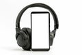 Headphones with Bluetooth technology on white background, with black phone paired for music lovers Royalty Free Stock Photo