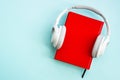 Headphones and books on blue background. Royalty Free Stock Photo