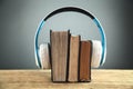 Headphones and books on wooden table. Audio book concept Royalty Free Stock Photo