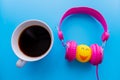 Headphones and coffee cup on blue background. Music concept. Top view with copy space Royalty Free Stock Photo