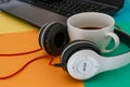 Headphones and Coffee cup on a difference colorful bright board background