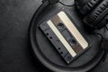 Headphones and compact cassette on black slate background Royalty Free Stock Photo