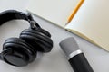 Headphones, microphone and notebook with pencil Royalty Free Stock Photo