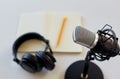 Headphones, microphone and notebook with pencil Royalty Free Stock Photo