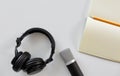 Headphones, microphone and notebook with pencil Royalty Free Stock Photo