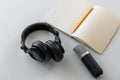 Headphones, microphone and notebook with pencil Royalty Free Stock Photo