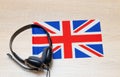Internet learning of English. Top view of headphones and flag of Great Britain. Royalty Free Stock Photo