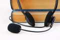 Headphones with a microphone and a stack of books on white background Royalty Free Stock Photo