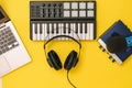 Headphones on music mixer, laptop and sound card on yellow background. The concept of workplace organization. Royalty Free Stock Photo