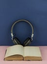 Headphones with open blank book page with copy space. Remote education concept Royalty Free Stock Photo