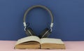 Headphones with open blank book page with copy space. Remote education concept Royalty Free Stock Photo