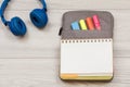 Headphones, open exercise book on bag-pencil case with color felt pens and marker on grey wooden boards Royalty Free Stock Photo