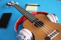 Headphones are putting on acoustic guitar on blue background closeup Royalty Free Stock Photo