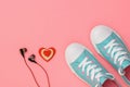 Headphones, red and white heart and turquoise sneakers on pink background. Color trend 2019. Sports style. Flat lay. Royalty Free Stock Photo