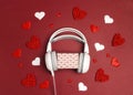 Headphones with romantic gift box and hearts on red background. St. Valentines Day music gift concept Royalty Free Stock Photo