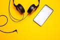Headphones and smart pnone on yellowl bakground Royalty Free Stock Photo