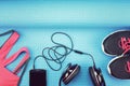 Headphones and sport accessories on blue yoga mat background.