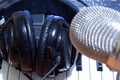 Headphones on synth piano keyboard and head of condenser microphone. Making music concept Royalty Free Stock Photo