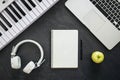 Headphones, synthesizer, laptop and notebook on a black background, top view. Royalty Free Stock Photo