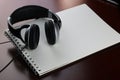 Headphones on a table next to the tablet and a clock Royalty Free Stock Photo