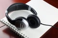 Headphones on a table next to the tablet and a clock Royalty Free Stock Photo