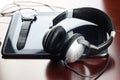 Headphones on a table next to the tablet and a clock Royalty Free Stock Photo