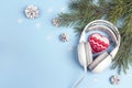 Headphones with winter heart, tree branches and snow cones on bl
