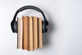 Headphones worn on a stack of old books on a white background. Audio library concept. Top view Royalty Free Stock Photo