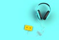 Headphones with yellow cassette tape on blue background, Top view with copyspace for your text