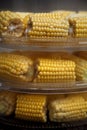 Heads of corn laid out for cooking in a double boiler. Corn broken into pieces in a steamer.