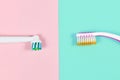 Electronic and traditional toothbrush comparison side by side on pink and green background