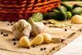 Heads of garlic and brushed denticles on the table with a basket