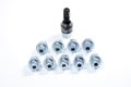 The heads for wheel locks lie in two rows and an extractor for removing locks on a white background.