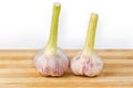 Heads of young purple garlic on cutting board, side view Royalty Free Stock Photo