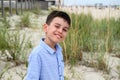 Headshot of adorable kid cute smiling standing against the backdrop of steppe thickets and sandy soil. Handsome child cute smiles Royalty Free Stock Photo