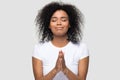 Headshot african female praying posing on grey background studio shot