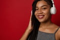 Headshot of attractive stunning delighted cheerful African young woman with stylish dreadlocks, wearing wireless headphones,