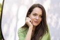 Portrait of young woman with beautiful green eyes and brunette hair sitting at sunglight Royalty Free Stock Photo