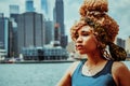 headshot beautiful young adult woman afro hairstyle with Manhattan New York City skyline in the background outdoors