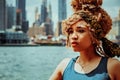 headshot beautiful young adult woman afro hairstyle with Manhattan New York City skyline in the background outdoors